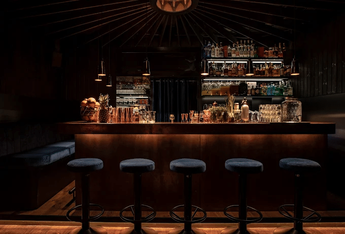 Dimly lit bar counter with bar stools at The Chapel Bar in Vienna