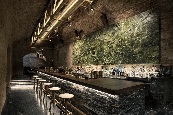 Underground brick vault at krypt. bar in Vienna with a marble bar counter and a green plant wall