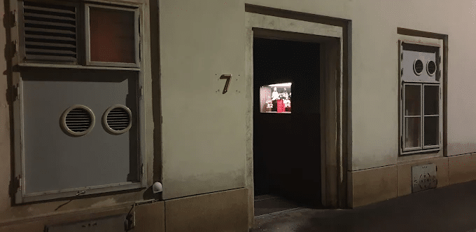 Unmarked entrance of Tür 7 bar in Vienna at night, with only a number 7 beside the door